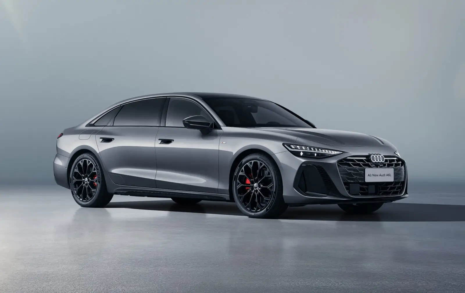 Серый седан Audi A6L спереди сбоку в студии
