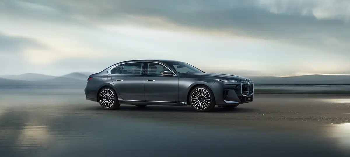 BMW 7 серии из Китая под заказ — серый седан в движении, вид сбоку