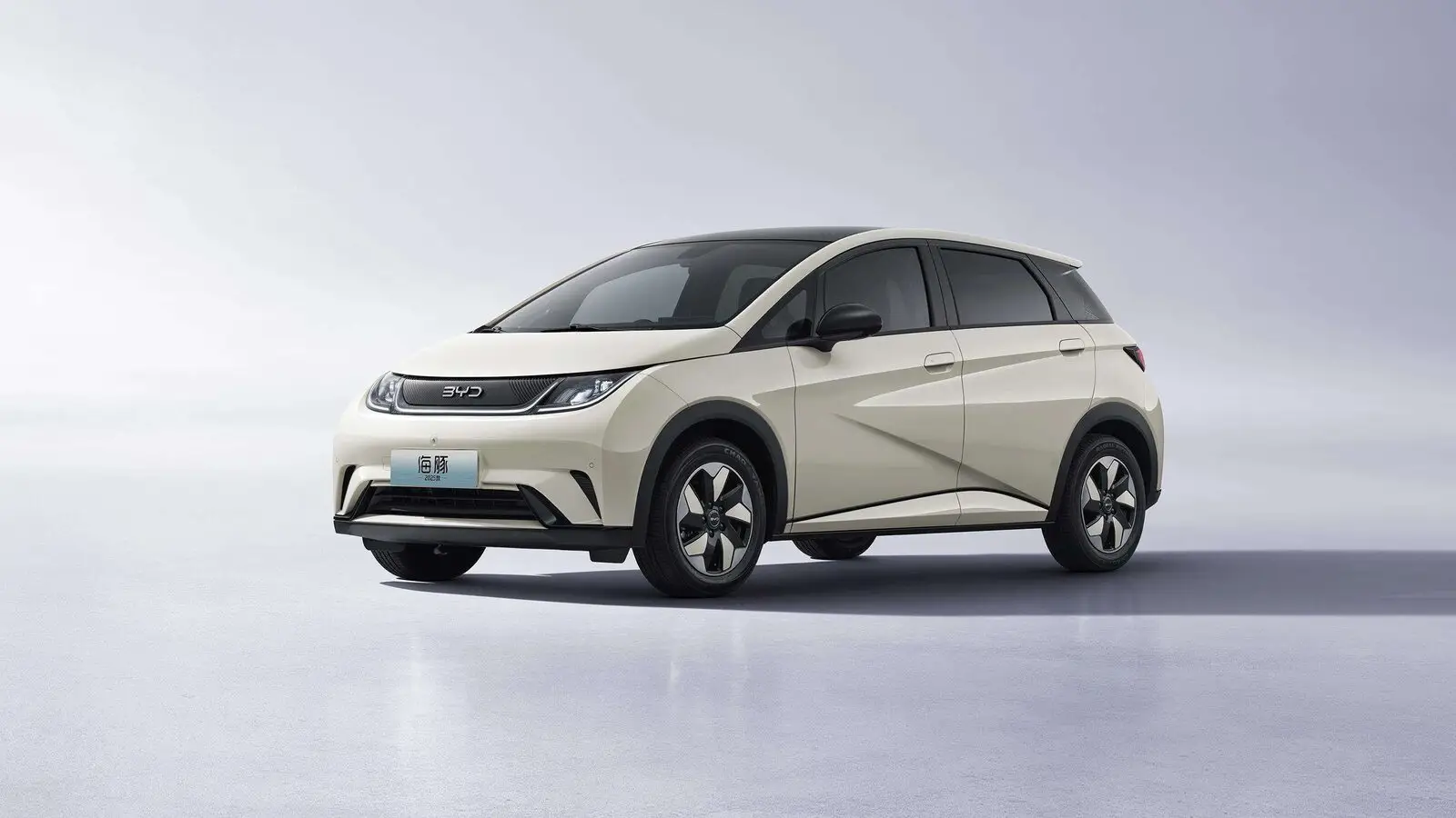 Белый электромобиль BYD Dolphin спереди сбоку в светлой студии