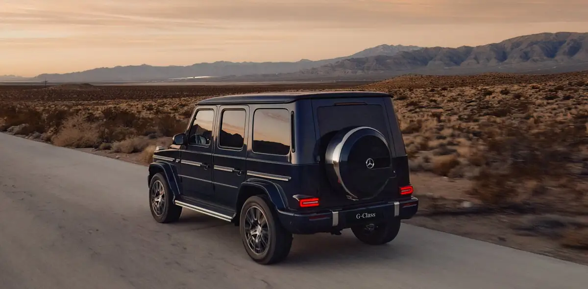 Mercedes-Benz G-Class (Мерседес G-Класс) из Китая под заказ — вид сзади в три четверти на дороге в сумерках