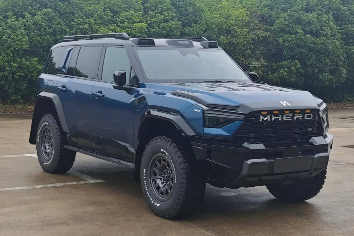 M-Hero 817 из Китая под заказ — синий внедорожник на площадке у зелёной изгороди, вид спереди в три четверти