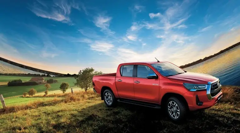 Toyota (Тойота) под заказ из ОАЭ — Hilux, красный пикап с двойной кабиной, вид спереди в три четверти