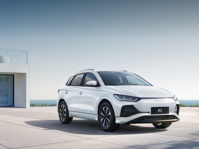Белый BYD e2 у современной архитектуры