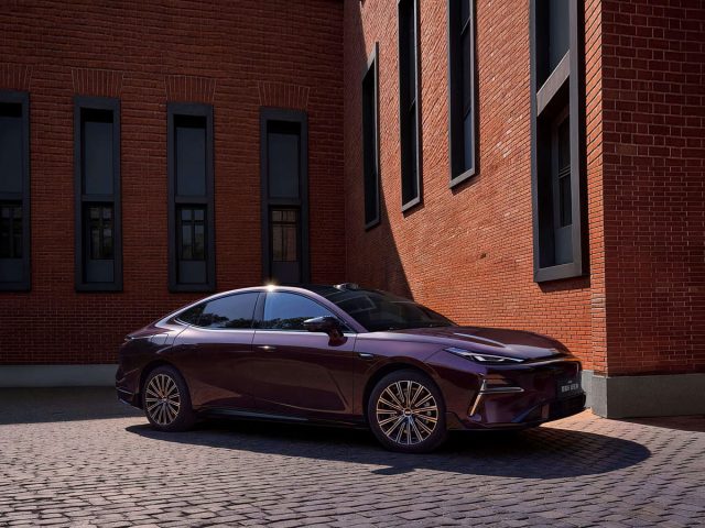 Фиолетовый Geely Starshine 8 у кирпичного здания
