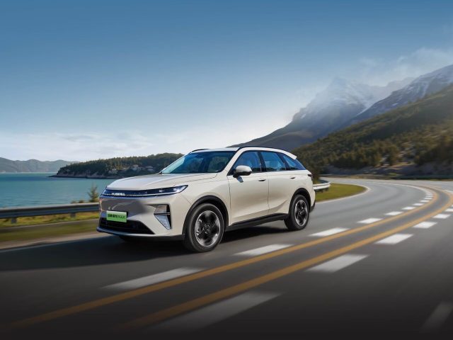 Haval Xiaolong Max второго поколения — вид спереди в три четверти на горной дороге