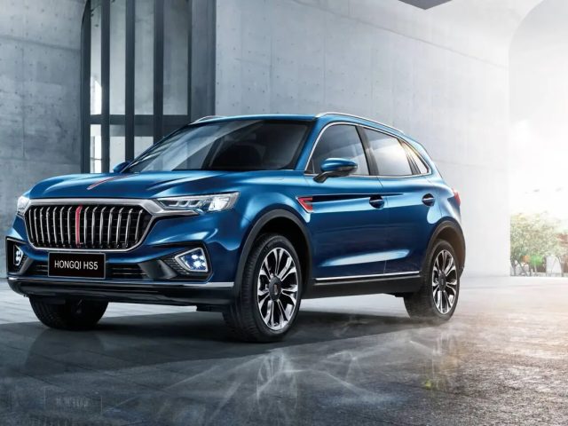 Синий HONGQI HS5 у современного здания, вид спереди в три четверти